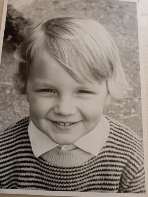 Christoph as a young boy in a striped jumper