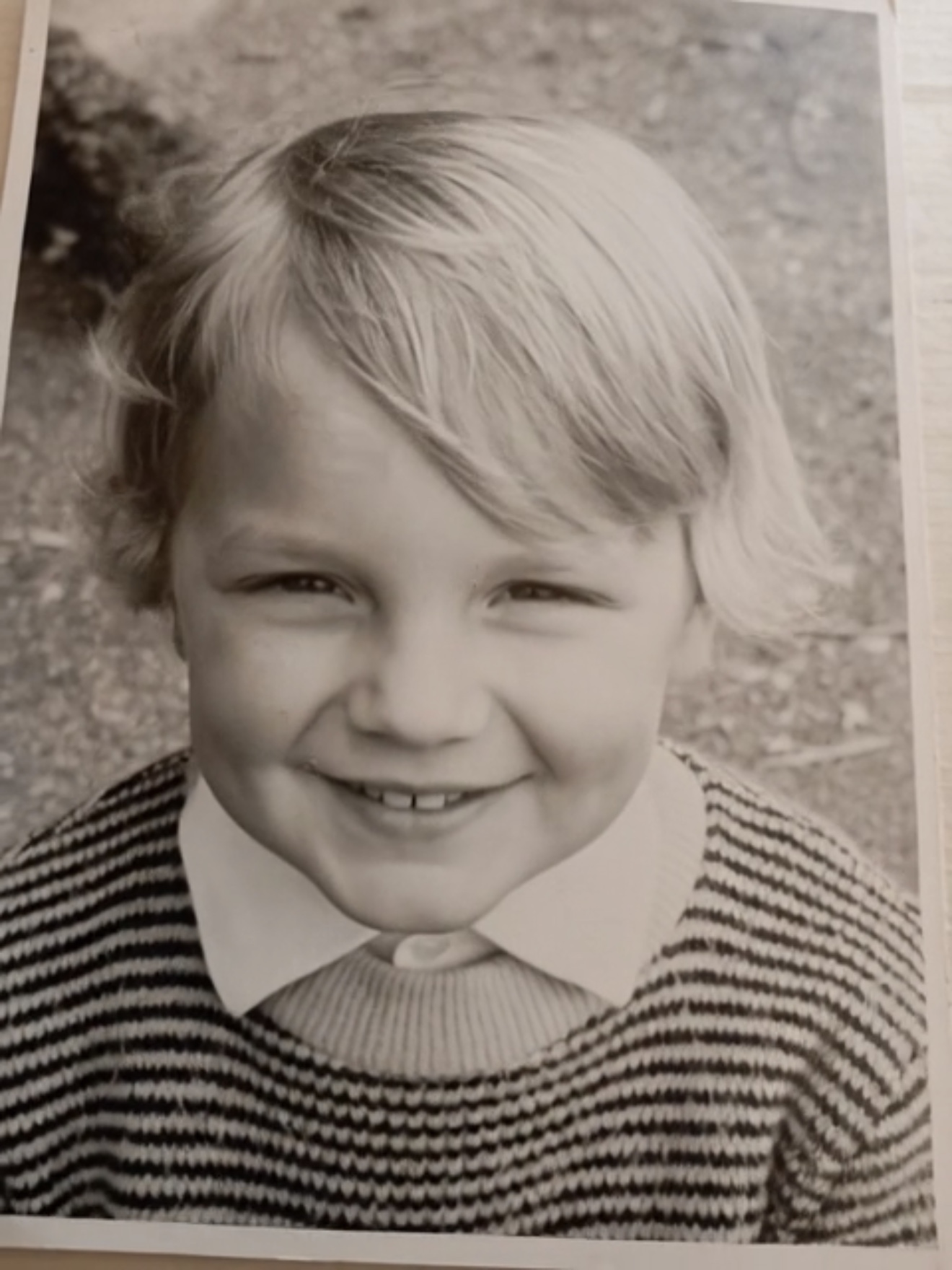 Christoph as a young boy, smiling in a striped jumper and a large white collar; the border of the original photograph is preserved.